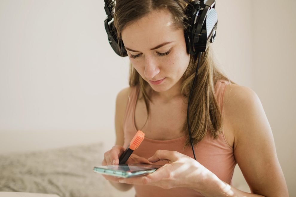 Woman with headphones holding smartphone